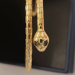 Gold tone snake 🐍 bracelet. Eyes done in  green crystals.